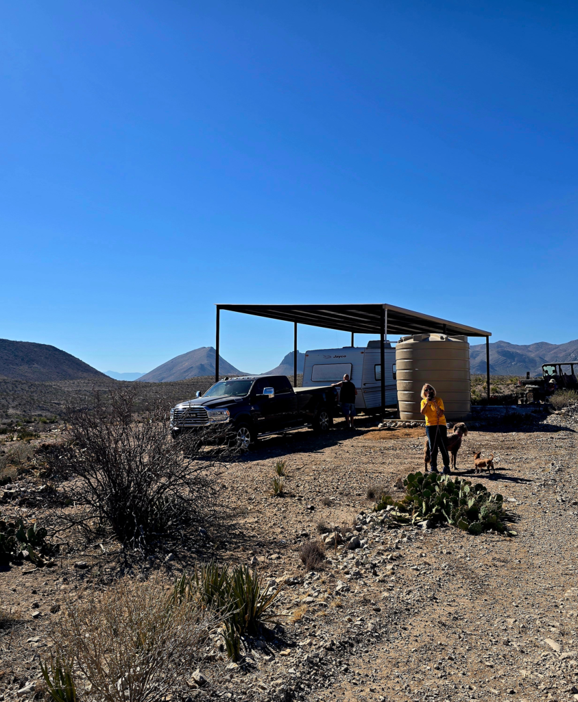 Remote RV land setup in West Texas with a camper parked under a shelter
